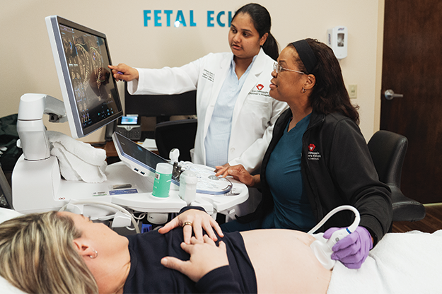 Dr. Akam and nurse performing fetal echo on pregnant woman